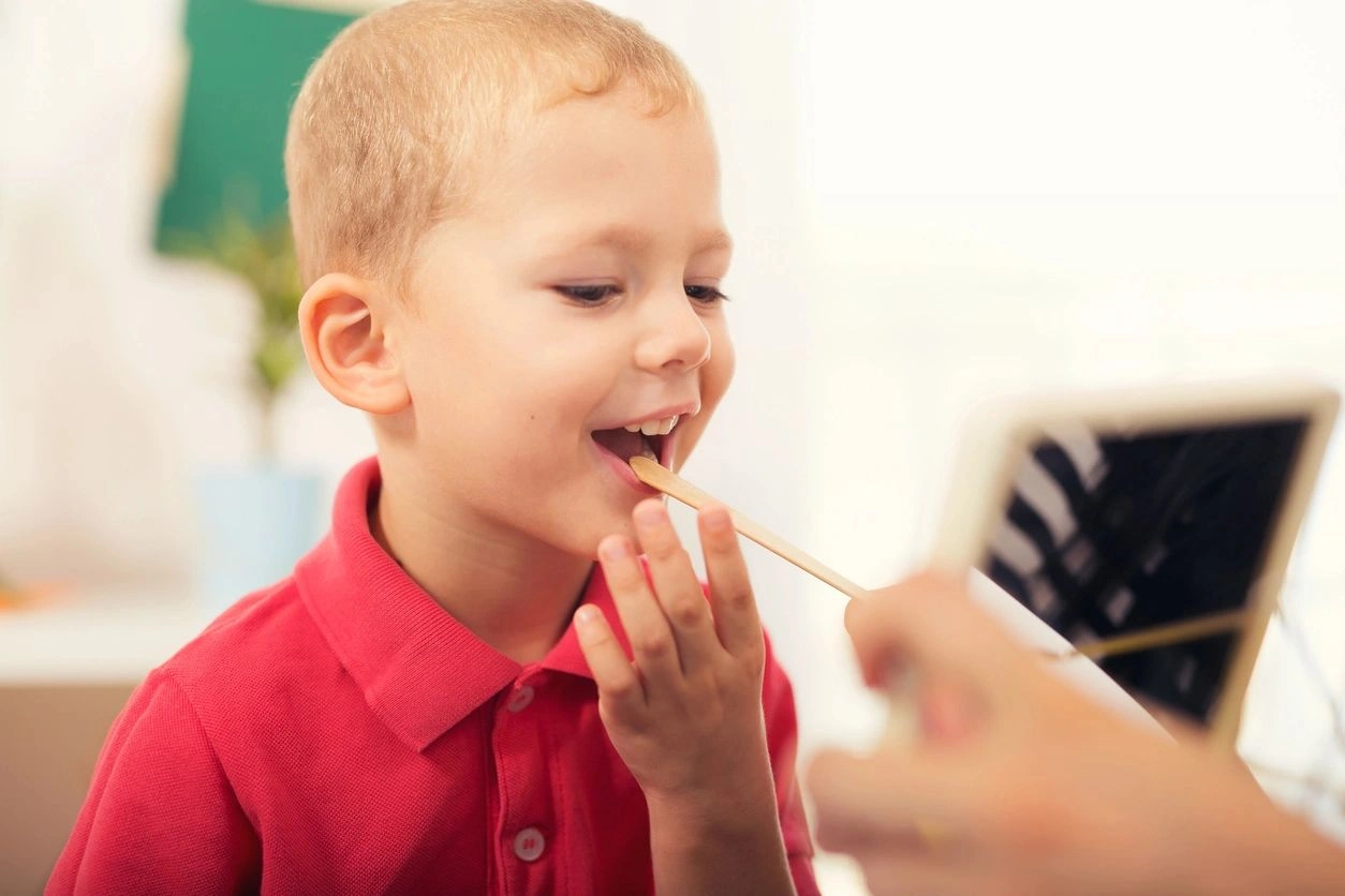 A child is being fed something by an adult.